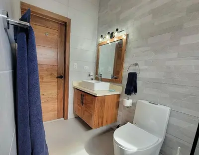 a bathroom with a toilet and a sink and a mirror at Villa Tranquila - Sosua Ocean Village in Sosúa