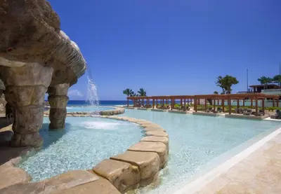 a swimming pool with a fountain in a resort at Villa Tranquila - Sosua Ocean Village in Sosúa