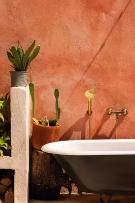 a white bath tub sitting next to a wall with cactus at Casa Grullon, an Oasis in the Colonial Zone in Santo Domingo