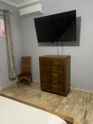 a bedroom with a dresser with a flat screen tv on the wall at Laguna beach in Sosúa