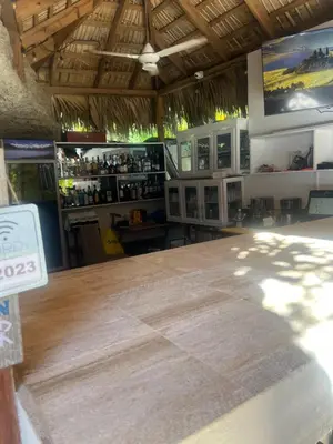 a bar with a large wooden table in a room at Laguna beach in Sosúa