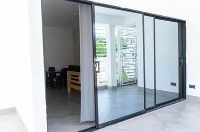 a room with sliding glass doors and a dining room at Appartement cosy avec terrasse in Santa Bárbara de Samaná