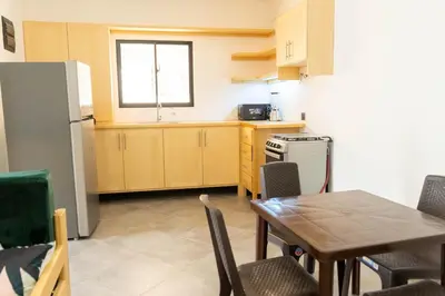 a kitchen with a table and a refrigerator at Appartement cosy avec terrasse in Santa Bárbara de Samaná