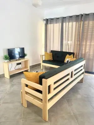 a living room with a couch and a tv at Appartement cosy avec terrasse in Santa Bárbara de Samaná
