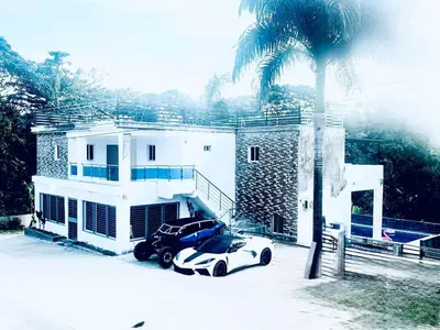 a car parked in front of a house with a palm tree at Double P Ranch 20 guests, BBQ and pool Buggy rental in Pedro Brand