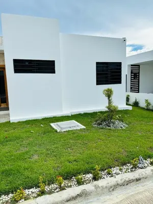 a white house with a green yard at El Rincón Soleado 1 in San Felipe de Puerto Plata