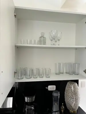 a row of glasses on a shelf in a kitchen at El Rincón Soleado 1 in San Felipe de Puerto Plata