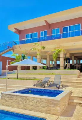 a building with two chairs and a swimming pool at Villa Barias in Las Calderas