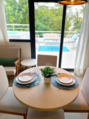 a wooden table with plates and glasses and a plant on it at Luxury Apt with Private Jacuzzi & Pool Near Beach in Las Terrenas