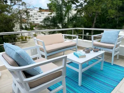 a patio with two chairs and a table and a couch at Luxury Apt with Private Jacuzzi & Pool Near Beach in Las Terrenas