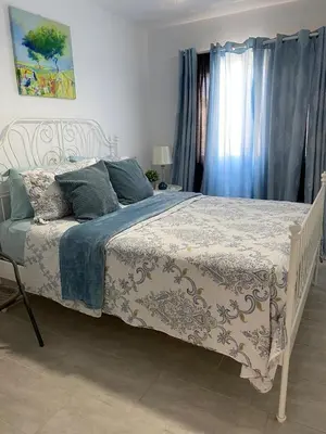 a bedroom with a bed with a blue and white comforter at Apartment in Riviera Colonial in Calero