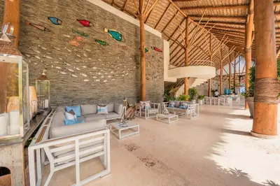 a room with couches and chairs and a brick wall at Charming two-bedroom apartment in Las Terrenas in Las Terrenas