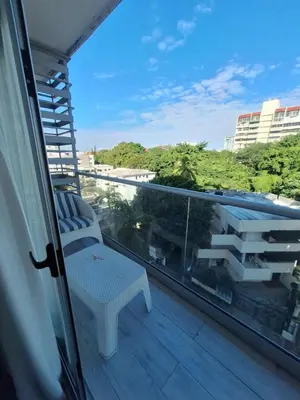 a balcony with a chair and a view of the city at Two-Bedroom Apartment in Santo Domingo in Santo Domingo