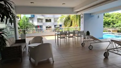 a patio with a table and chairs and a pool at Two-Bedroom Apartment in Santo Domingo in Santo Domingo