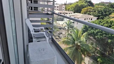 a white chair sitting on a balcony with a view at Two-Bedroom Apartment in Santo Domingo in Santo Domingo