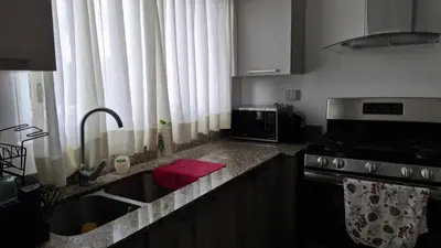 a kitchen with a sink and a counter with a microwave at Two-Bedroom Apartment in Santo Domingo in Santo Domingo