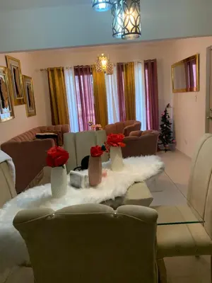 a living room with a table with red flowers on it at Cómodo y acogedor in Los Paredones