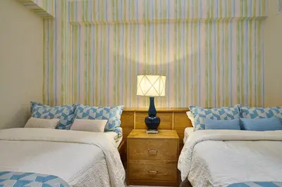 a bedroom with two beds and a lamp on a night stand at Escape Beachfront Condos Las Olas Juan Dolio in La Puntica de Juan Dolio