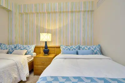 a bedroom with two beds and a lamp on a night stand at Escape Beachfront Condos Las Olas Juan Dolio in La Puntica de Juan Dolio