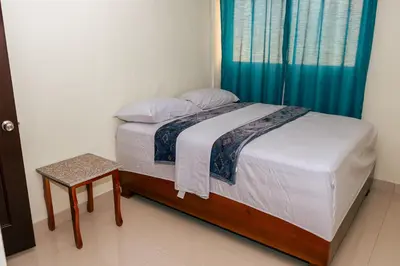 a bedroom with a bed with a blue curtain at Apartahotel Santo Domingo EsteRD - Aeropuerto Las Americas in La Viva