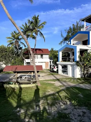 a view of a house with a palm tree at Front Beach Punta Rucia Villa in Punta Rucia