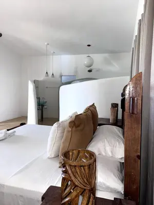 a bedroom with a white bed with a wooden headboard at Front Beach Punta Rucia Villa in Punta Rucia