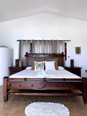 a large bed with a wooden headboard in a bedroom at Front Beach Punta Rucia Villa in Punta Rucia