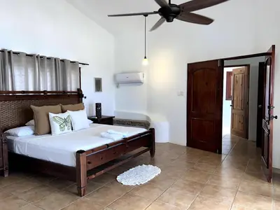 a bedroom with a bed and a ceiling fan at Front Beach Punta Rucia Villa in Punta Rucia