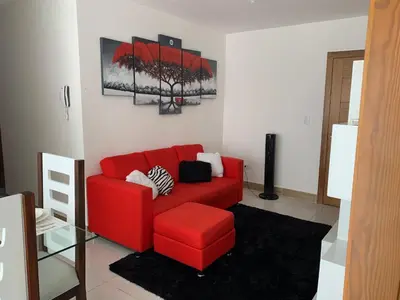 a red couch sitting in a living room at Juan Bosch apartament in Santo Domingo