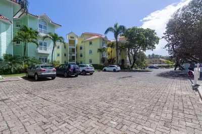 a parking lot with cars parked in front of buildings at Oceanfront Apartment in Cabarete with Pool and Beach Access in Cabarete
