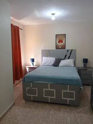 a bedroom with a bed with a blue comforter at SDQ Apartment Marbella 4 in La Ureña