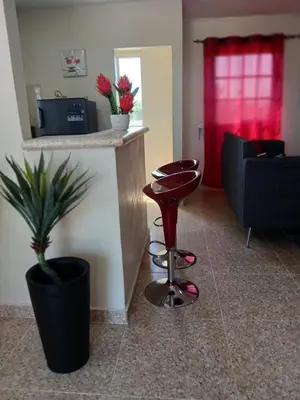 a living room with a red stool and a counter at SDQ Apartment Marbella 4 in La Ureña