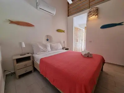 a bedroom with a bed with a red blanket at Beachfront Villa Tabiki at Playa Coson, Las Terrenas, Dominicana in Las Terrenas