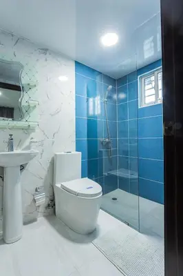 a bathroom with a toilet and a glass shower at America Apartment in Santo Domingo