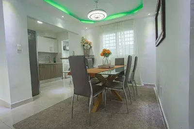 a kitchen and dining room with a table and chairs at America Apartment in Santo Domingo