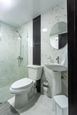 a white bathroom with a toilet and a sink at America Apartment in Santo Domingo