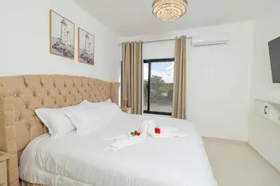 a bedroom with a white bed with two towels on it at Serene 2-Bedroom Coastal Retreat in Bayahibe in San Rafael del Yuma