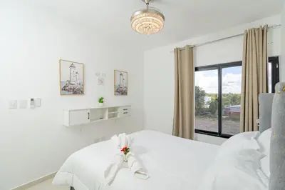 a white bedroom with a bed and a window at Serene 2-Bedroom Coastal Retreat in Bayahibe in San Rafael del Yuma