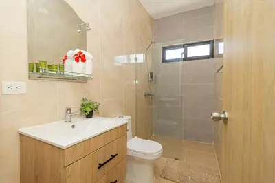 a bathroom with a toilet and a sink and a shower at Serene 2-Bedroom Coastal Retreat in Bayahibe in San Rafael del Yuma