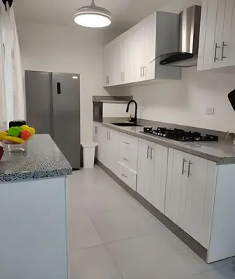 a kitchen with white cabinets and a stainless steel refrigerator at Bayahibe Rose C - Gray Elegance in San Rafael del Yuma