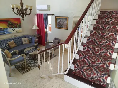 a living room with a staircase with a blue couch at Residencial Oasis in Juan López