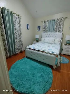 a bedroom with a bed and a green rug at Residencial Oasis in Juan López