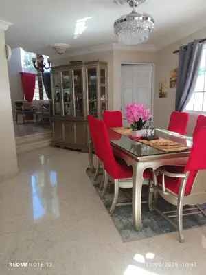 a dining room with a table and red chairs at Residencial Oasis in Juan López