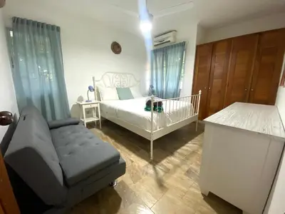 a bedroom with a bed and a crib and a chair at Fantástico Lugar en el Centro de los Corales RD in Punta Cana