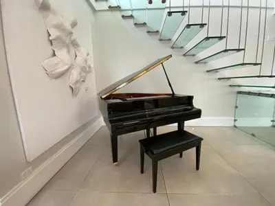 a piano and a stool in a room with stairs at Hermoso apartamento en el centro de la coudadt in Santo Domingo