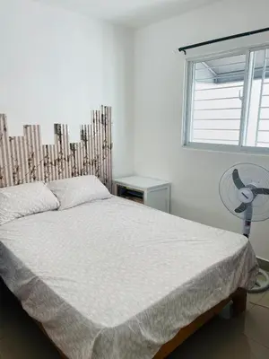 a bedroom with a bed and a fan and a window at Apartamento Bello y Amueblado in Jacagua