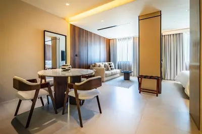 a room with a table and chairs and a bedroom at Nohian Collection Hotels in Santiago de los Caballeros