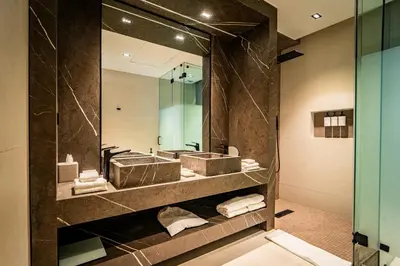 a bathroom with two sinks and a large mirror at Nohian Collection Hotels in Santiago de los Caballeros
