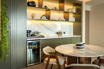 a dining room with a table and a kitchen at Nohian Collection Hotels in Santiago de los Caballeros