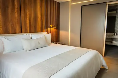a bedroom with a large white bed with white pillows at Nohian Collection Hotels in Santiago de los Caballeros